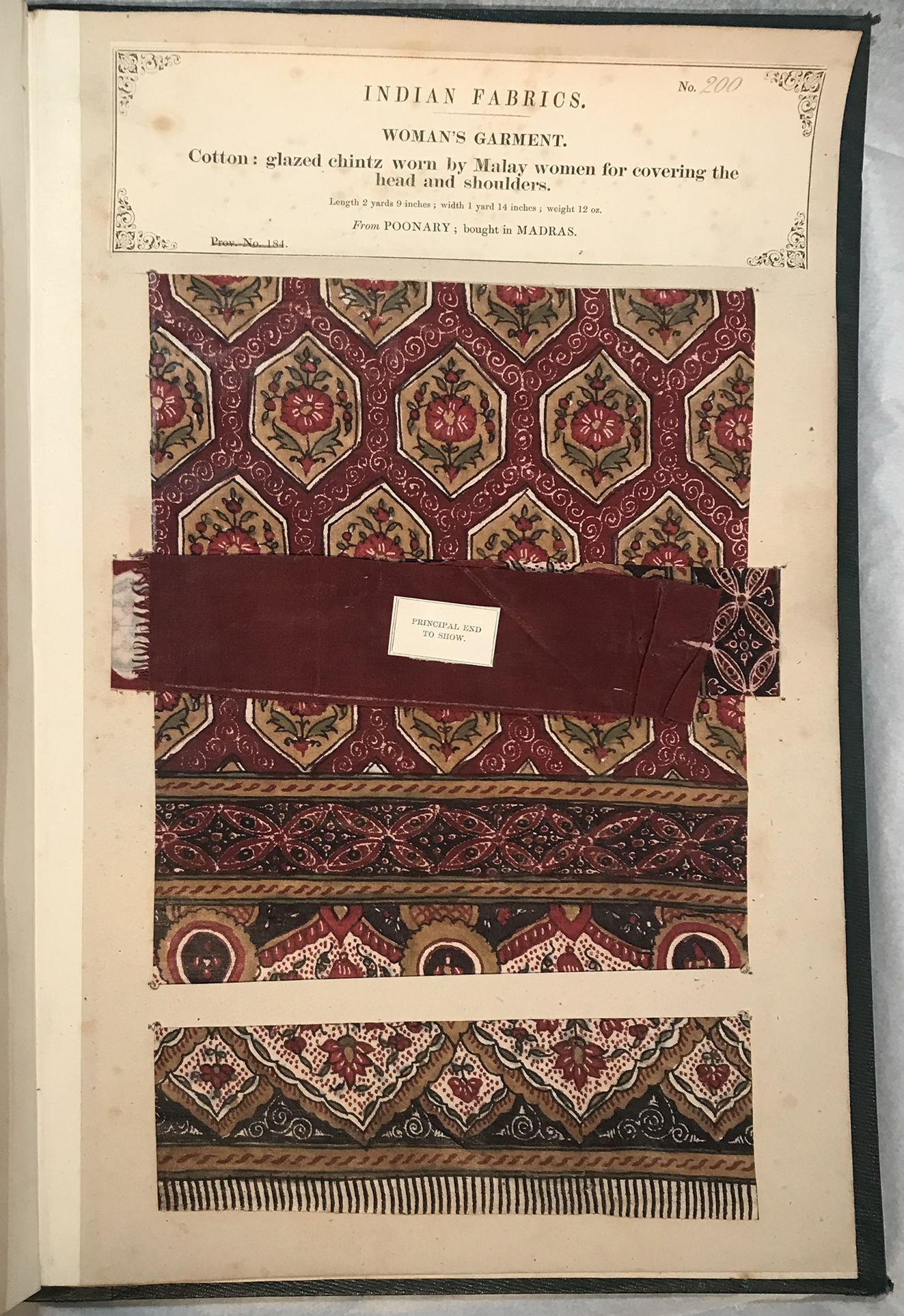 A page of a book displaying a burgundy patterned textile piece.