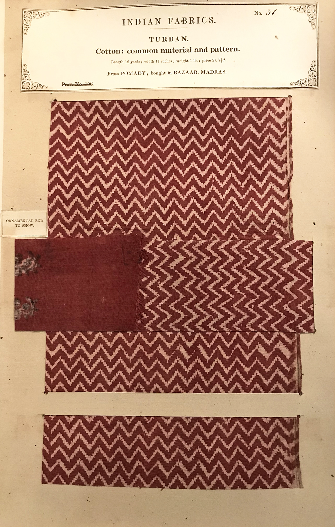 A page of a book showcasing a piece of patterned red cloth.