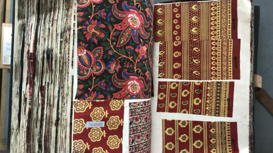 A large book with pages of colourful fabrics.