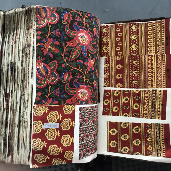 A large book with pages of colourful fabrics.