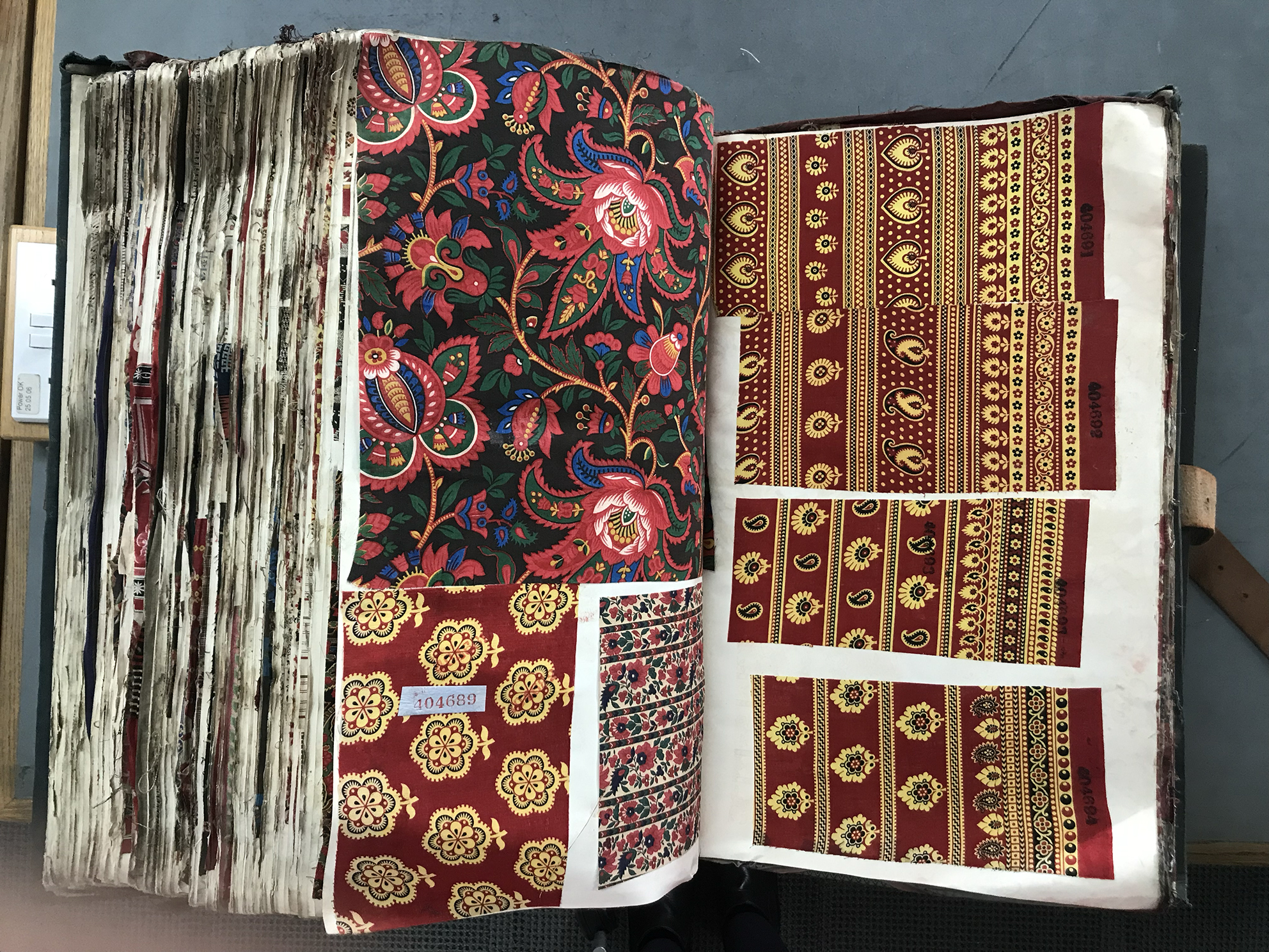 A large book with pages of colourful fabrics.