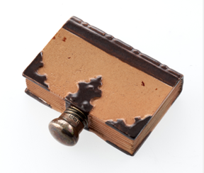 A small brown and beige bottle shaped like a book.