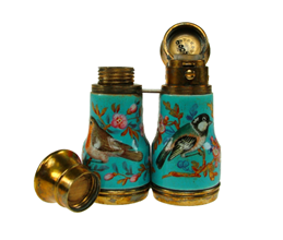 A teal and gold glass bottle in the shape of opera binoculars