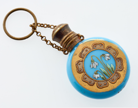 A circular glass blue bottle decorated with flowers.