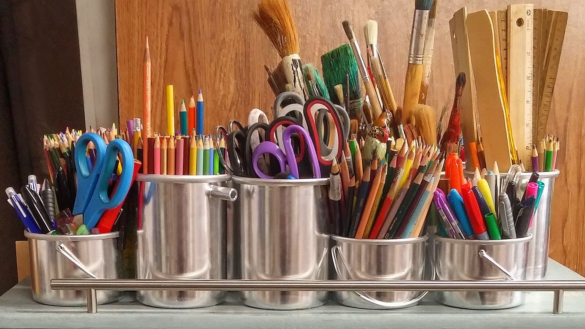 Image of scissors and pencils in silver pots.