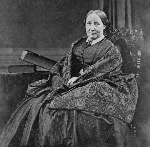 Portrait of a women sat in a grand chair in black and white.