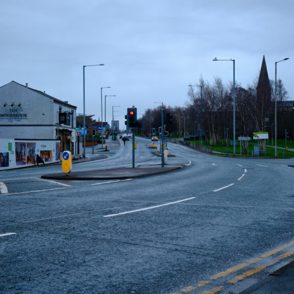 Image of a road with traffic lights and cars.