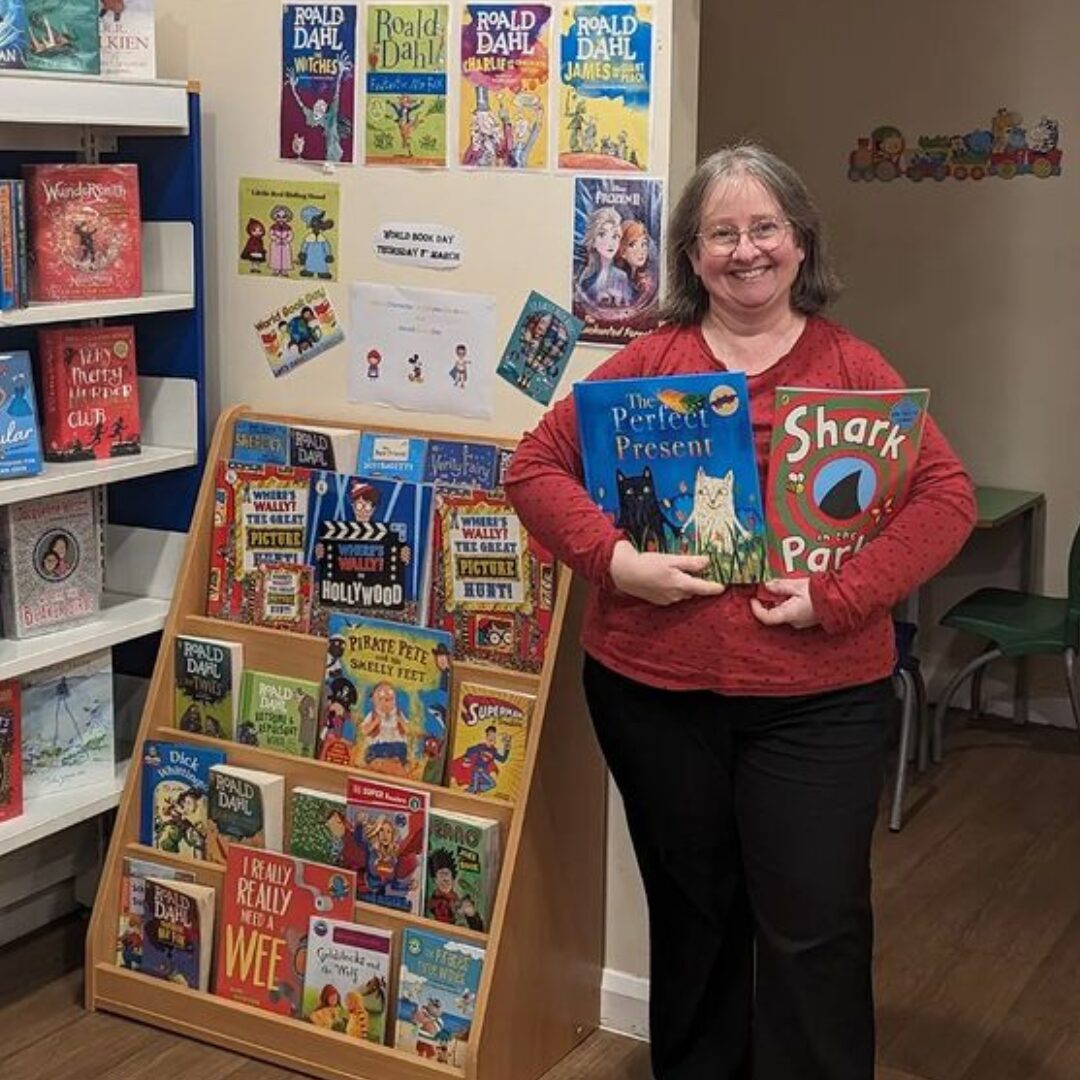 Library assistant Janet stood in next to books.