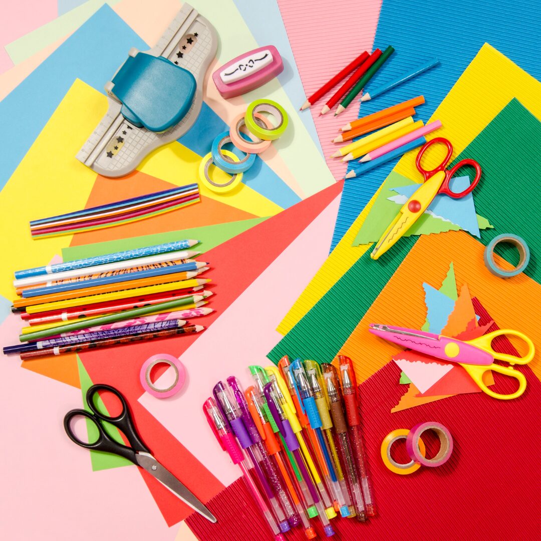 Colourful craft items laid out on a pink table.
