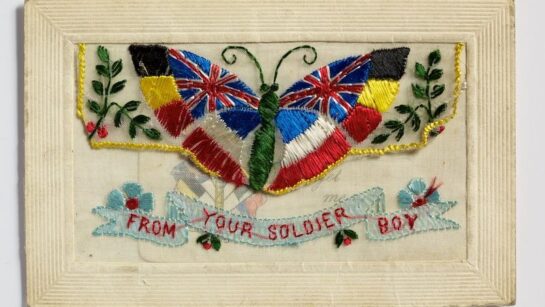 A postcard featuring a colourful embroidered butterfly.