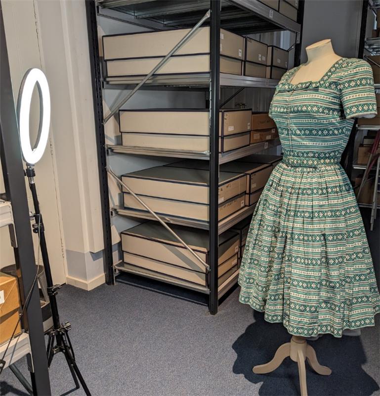 A green and white geometric patterned dress and a ring light.
