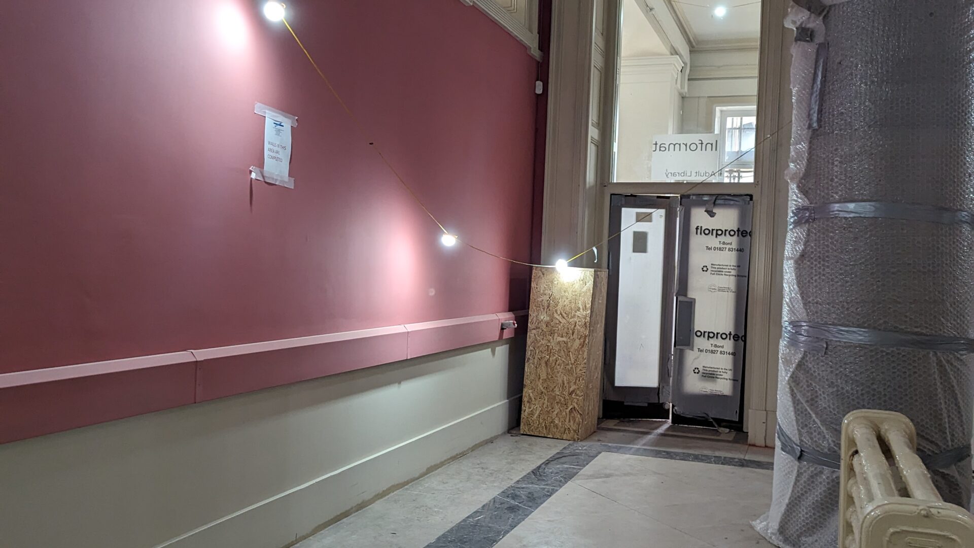 Image of a section of the Ground Floor Rotunda featuring a white radiator and deep pink wall colour.