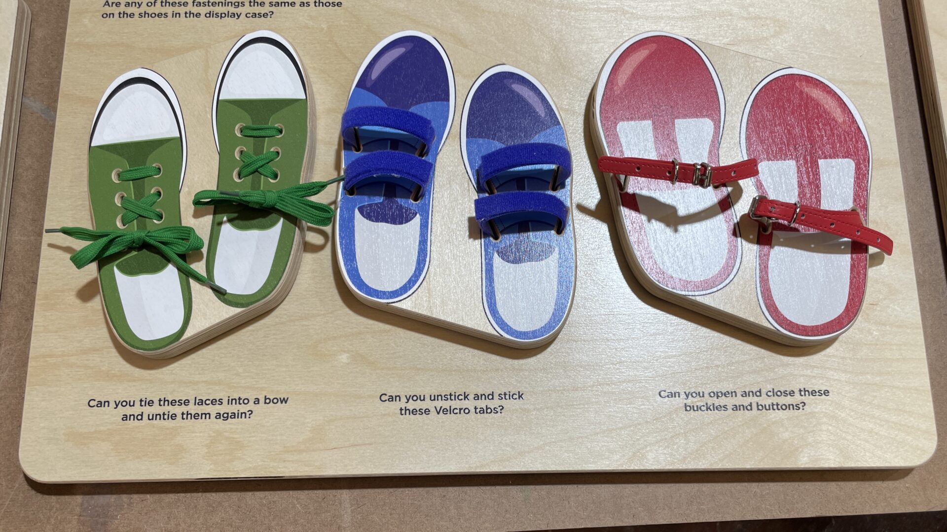 A wooden board featuring colourful pairs of shoes.