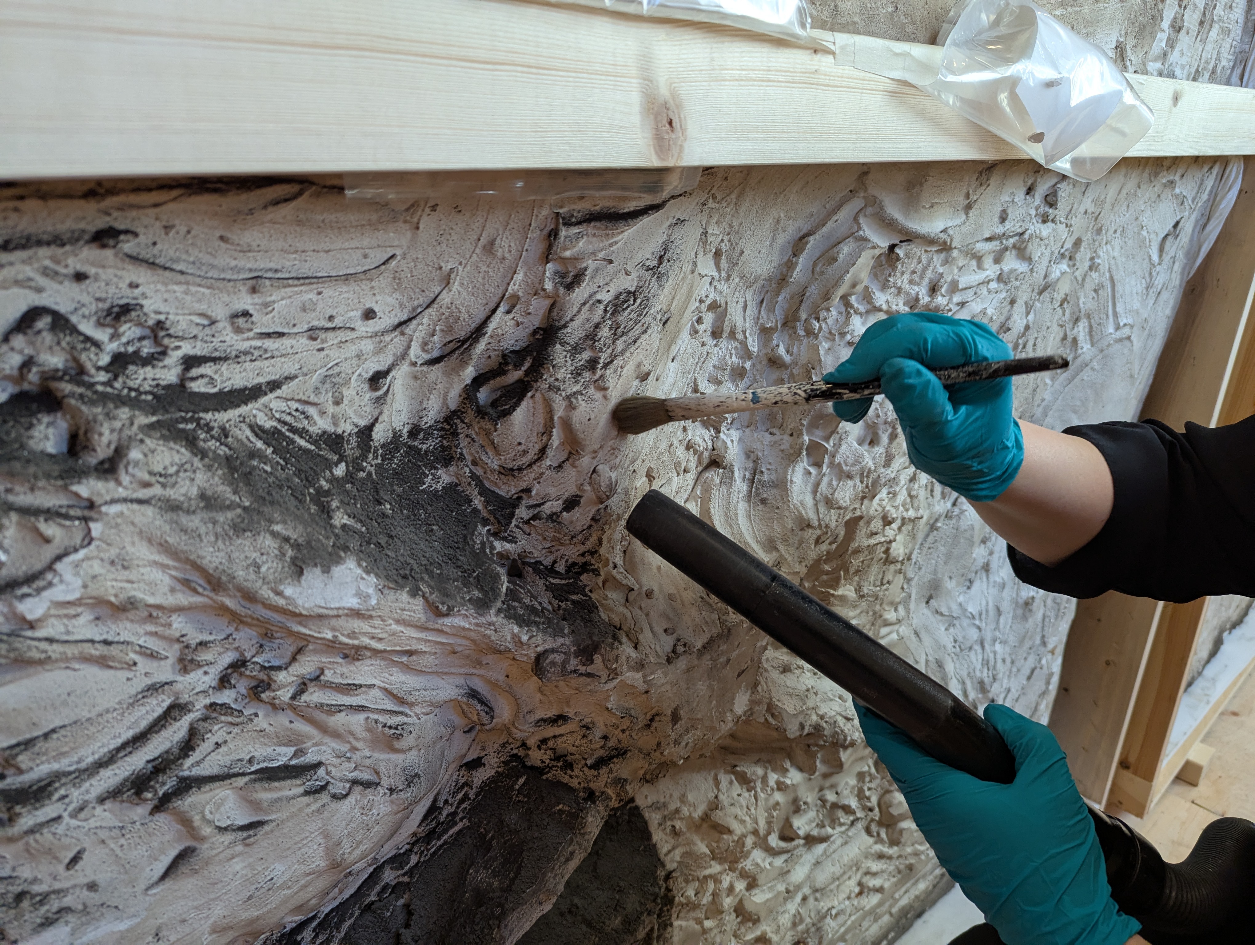 Image of a conservation specialist holding a brush on stone