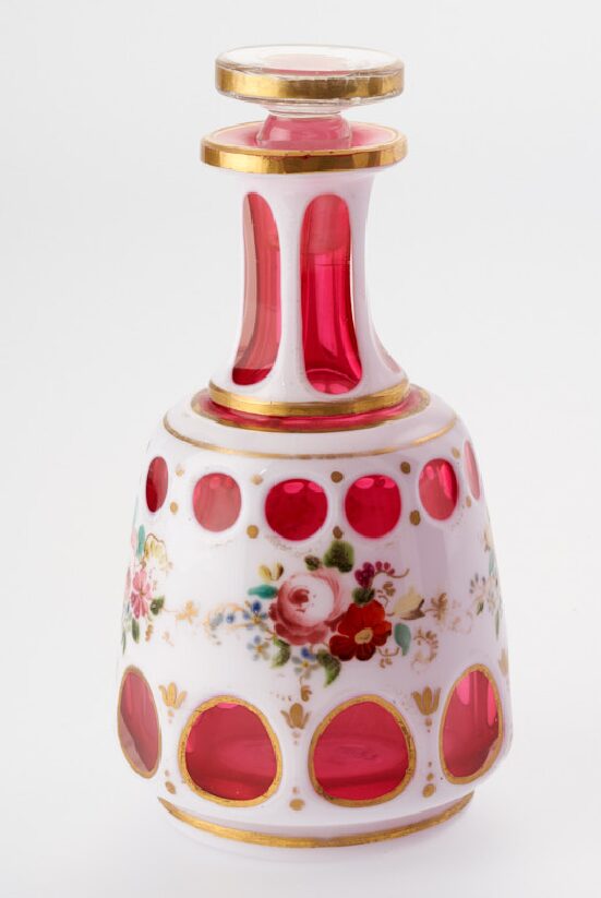 A pink and white toilet bottle with a floral design.