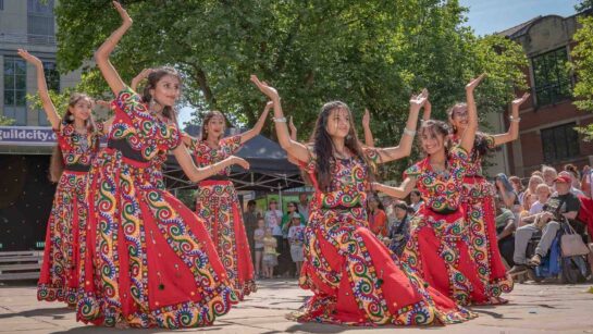 A dance troupe in colourful red dresses.