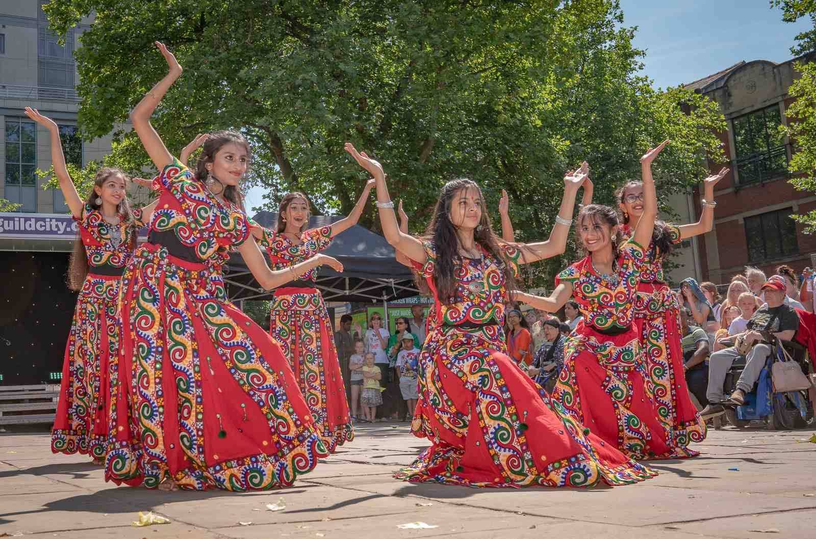 A dance troupe in colourful red dresses.