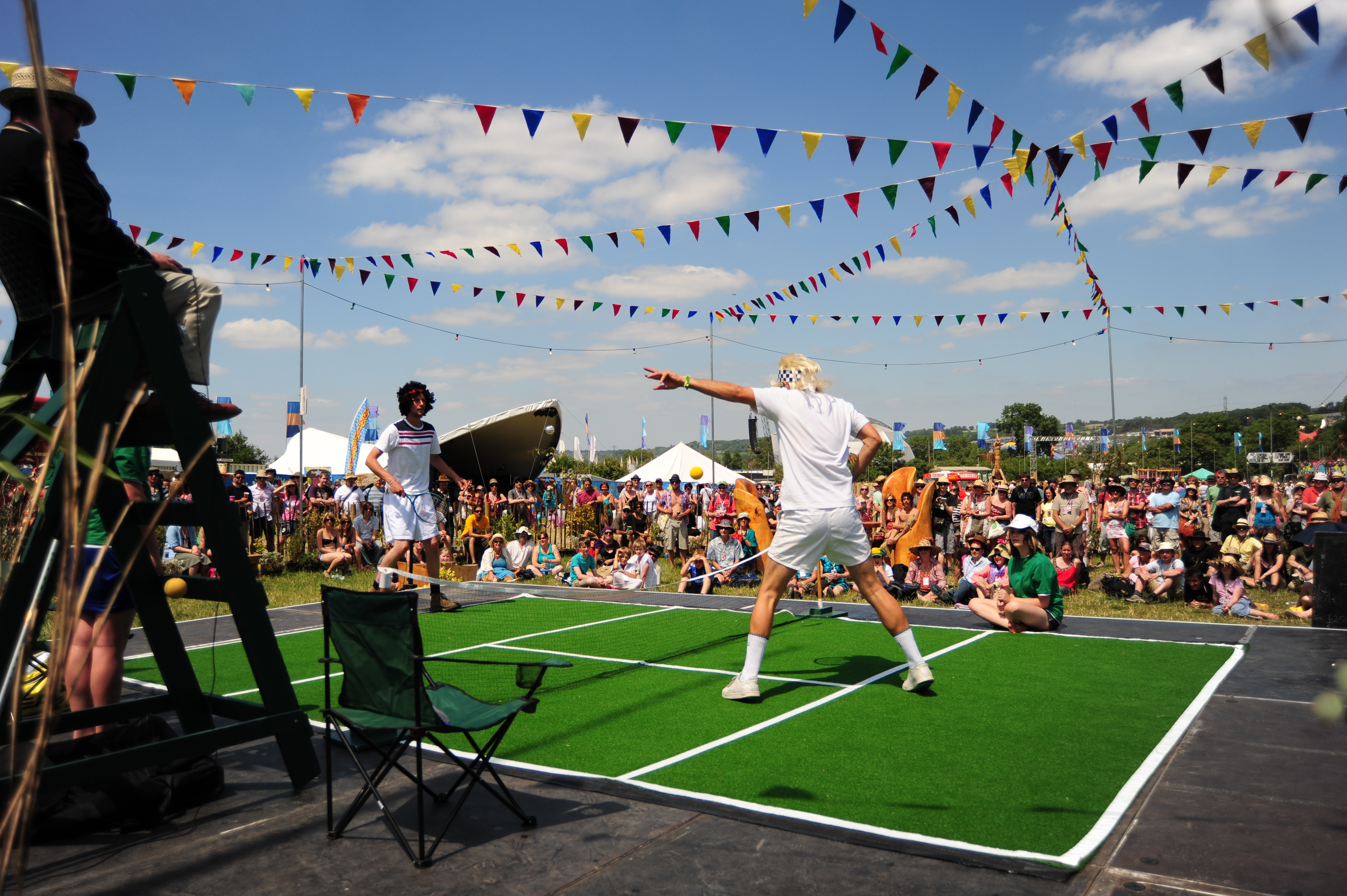 Two people on a tennis court in front of a crowd of people.